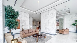Um hall amplo com uma grande área de estar, uma mesa de centro e um vaso de planta.