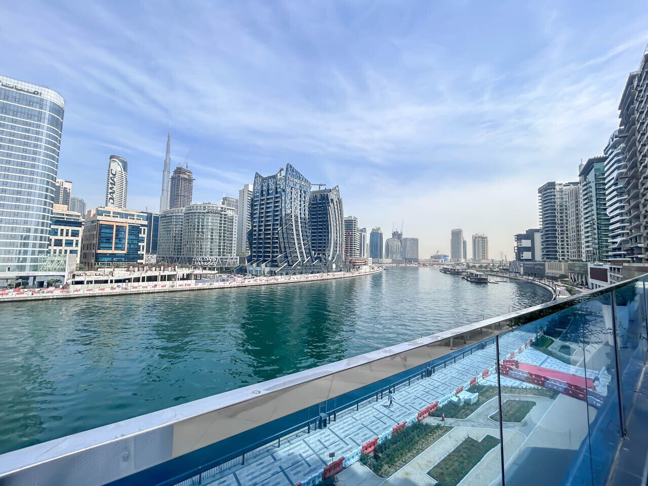 A waterfront view of a modern cityscape with high-rise buildings and a marina.
