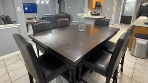 Una cucina moderna con isola centrale, elettrodomestici integrati e zona pranzo con un tavolo grande e sedie.