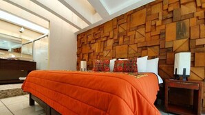 Ein modernes Schlafzimmer mit einem großen Bett, einer Wand mit Holzvertäfelung und einem Nachttisch mit Lampe.