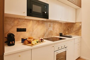 A modern kitchen with a built-in microwave, a sink, and a stove.