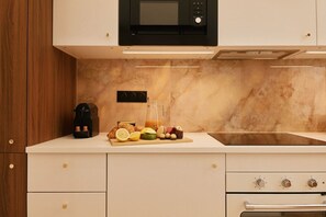 Eine moderne Küche mit Mikrowelle, Kaffeemaschine und einem Frühstücksbuffet auf der Arbeitsfläche.