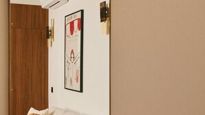 Una sala de estar con un sofá, una mesita auxiliar y un espejo que refleja la habitación.
