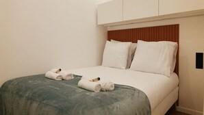 Una habitación de hotel con una cama, almohadas y toallas enrolladas.