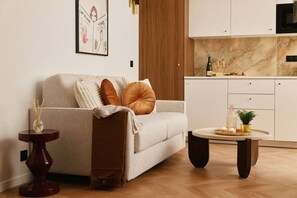 Un salon moderne avec un canapé, une table basse et une table d’appoint sur laquelle est posé un vase.