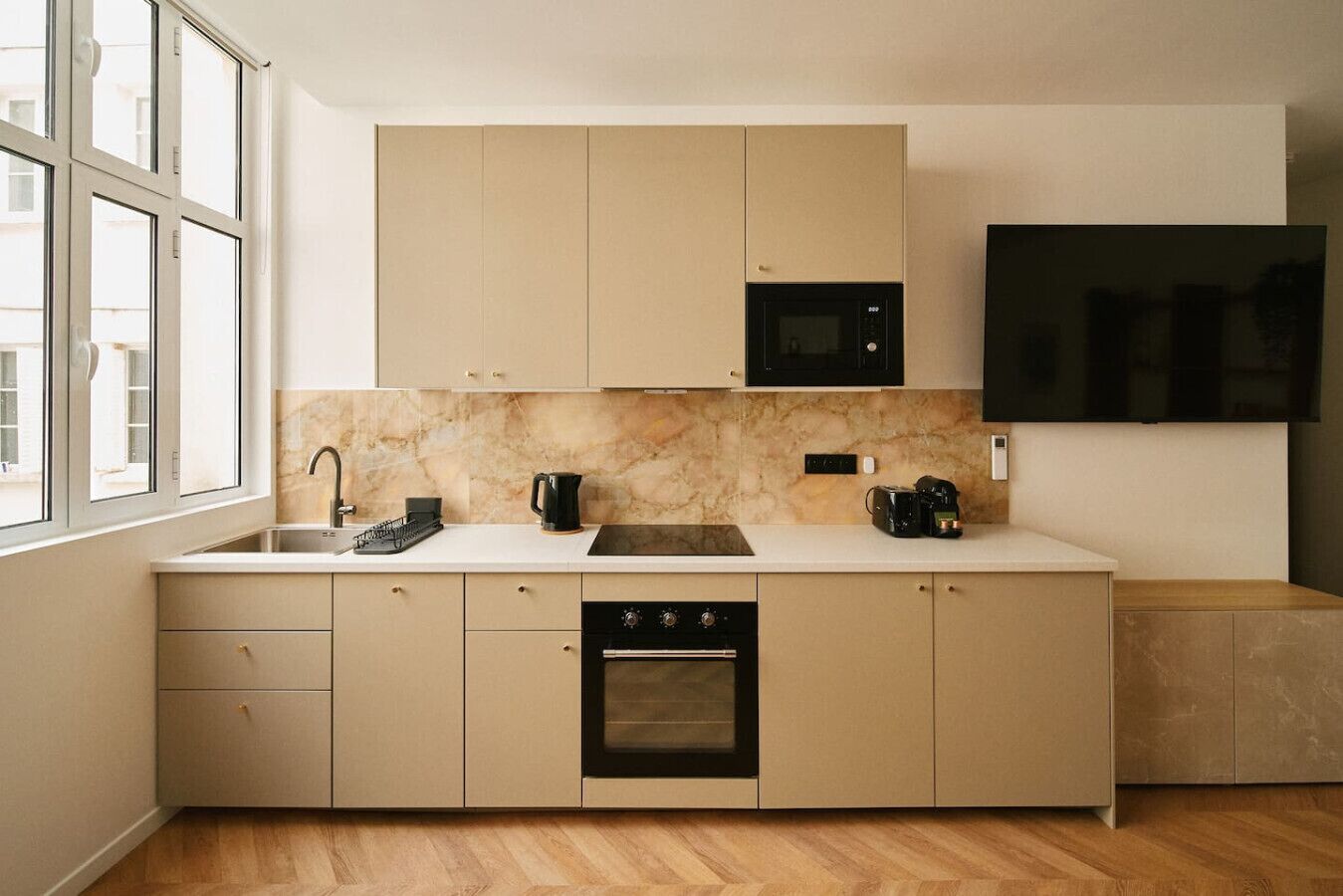 A modern kitchen with a built-in oven, a microwave, and a coffee maker on the countertop.