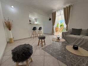 Ein modernes Wohnzimmer mit einer Couch, einem Couchtisch und zwei Barhocker.