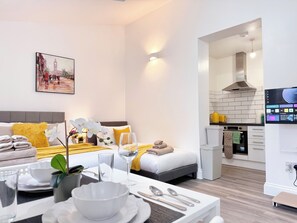 Ein modernes Hotelzimmer mit einem Bett, einem Esstisch mit einer Schüssel und einem Fernseher, der eine Speisekarte zeigt.