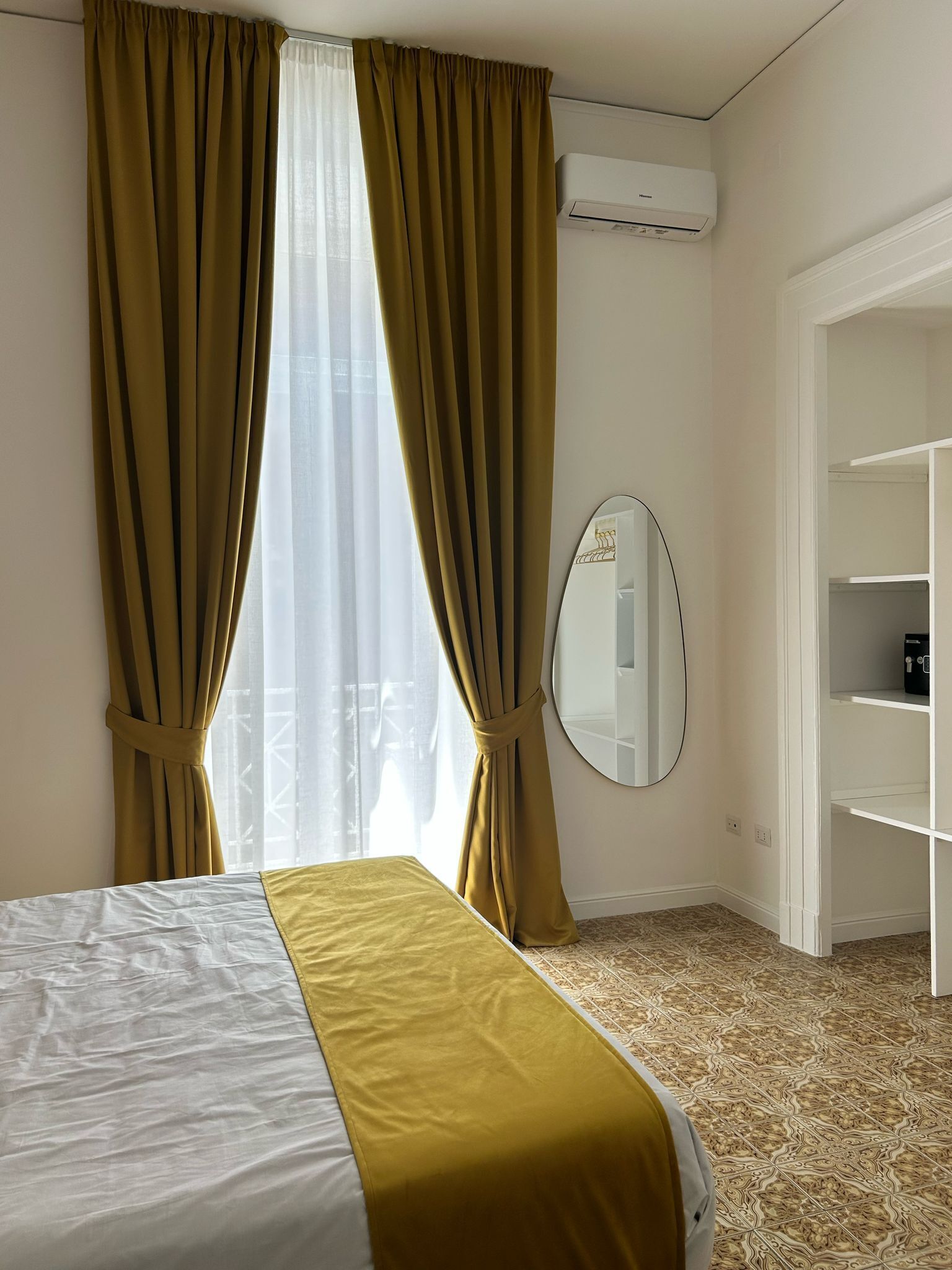 Een hotelkamer met een bed, een spiegel en een kledingkast.