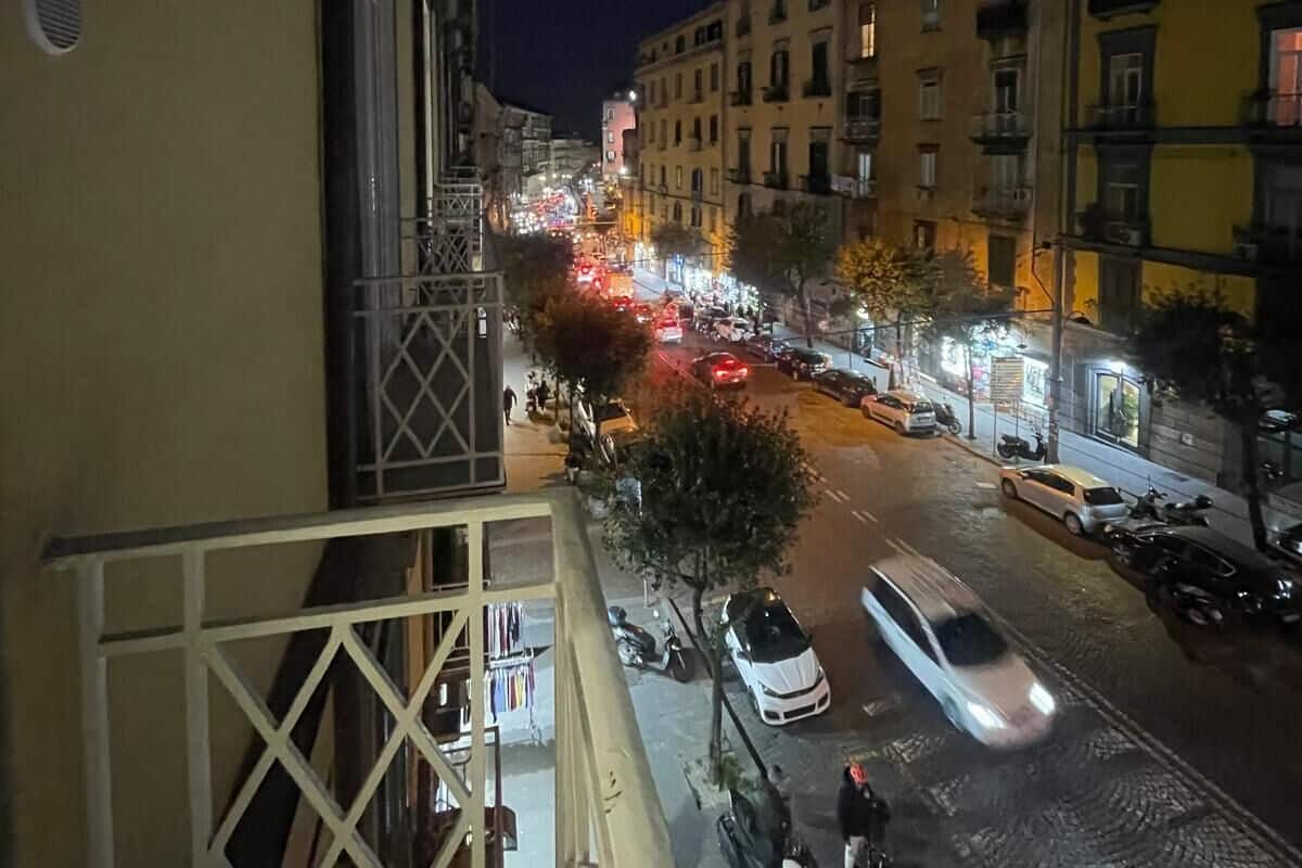 A nighttime view of a city street from a balcony.