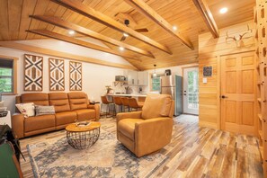 Una sala acogedora con sofá y sillón, una mesita de centro y un tapete estampado.