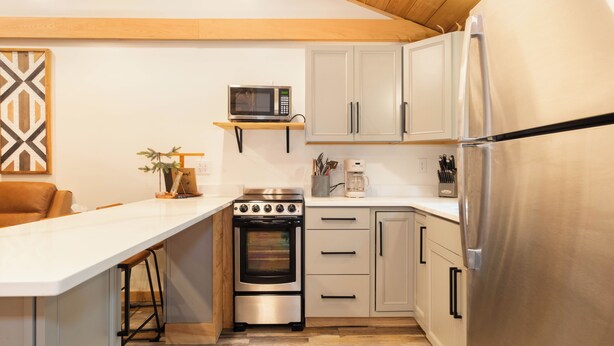 A modern kitchen with a built-in oven, microwave, and stainless steel refrigerator.