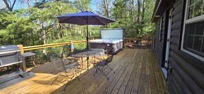 A wooden deck with a grill, a table with chairs, and a hot tub. - Relaxing Deep Creek Escape w/ Hot Tub (Oakland)