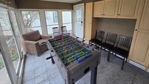 Ein Zimmer mit einem Kicker, einer Couch und Holzsäcken.