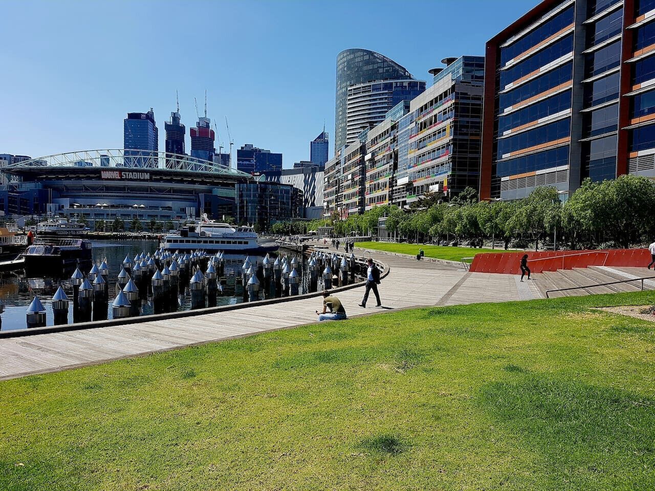 A waterfront area with a modern building, a bridge, and a body of water.