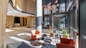 A modern lobby with seating, a coffee table, and hanging spherical lights. - Docklands Melbourne CBD Views (Docklands)