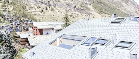 A mountain village with traditional wooden houses and modern buildings with solar panels.