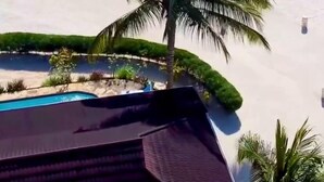 Ein Resort mit Pool, Palmen und Sandstrand.