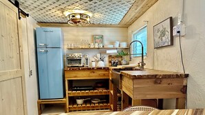 A compact kitchen with a blue refrigerator, wooden cabinets, a built-in oven, and a wooden countertop. - Old Florida bungalow on a tranquil Gulf Island Perfect for Couples or Anglers (Spring Hill)