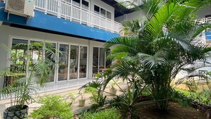 A modern building with a blue roof, large glass doors, and a balcony with white railings. - Grand Mahoni Hotel (Banda Aceh)