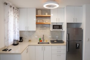 Fridge, microwave, coffee/tea maker, cookware/dishes/utensils