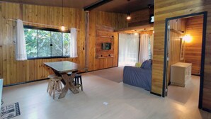 Un intérieur en bois comprenant une table à manger, un canapé et un téléviseur.