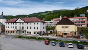 A hotel with a central courtyard and a parking lot with several cars.