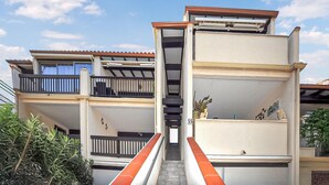 A multi-story building with a central staircase, balconies, and a flat roof. - Beach front home in Saint-Cyprien Plage (Saint-Cyprien Plage)