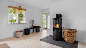 Een modern interieur met een open haard, houten vloeren en grote ramen.