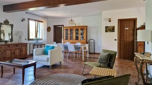 Un salon spacieux comprenant un coin repas, des meubles en bois et un grand meuble de rangement.