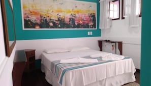 Comfortable retreat with a single bed, nightstand, and wall-mounted shelf, featuring a unique abstract art piece.