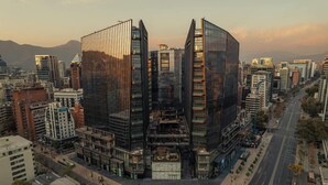 A modern urban area with high-rise buildings, including a prominent glass skyscraper with a unique design.