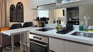 A modern kitchen with a white countertop, stainless steel appliances, and a built-in oven.