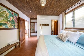 A bedroom with a large bed, a wooden ceiling, and a tropical-themed wall painting. - Casa del Alma: Laguna Villa with Infinity Pool and Dock (La Laguna Número 1)