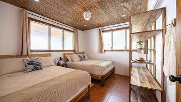 Una habitación con dos camas, techo de madera y ventana con vistas.