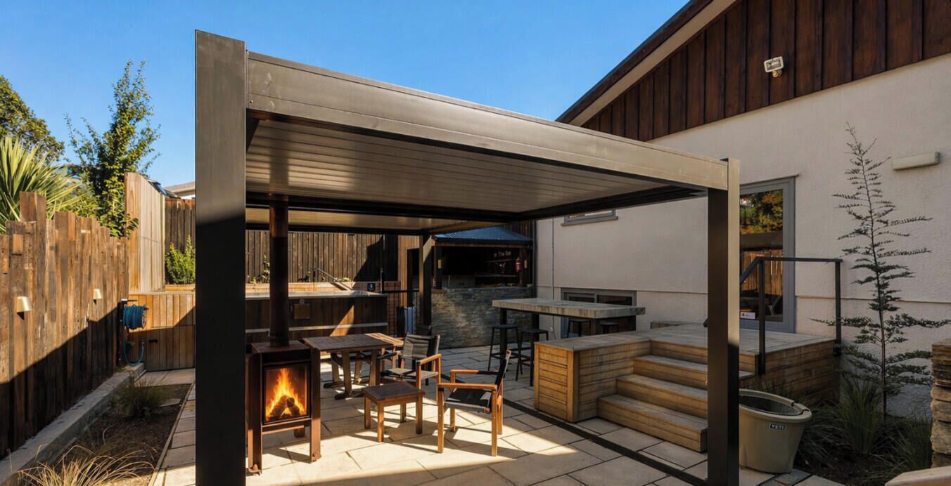Un patio al aire libre con estufa de leña, asientos y chimenea de piedra.