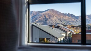 Vista a través de una ventana de un paisaje montañoso con edificios residenciales.