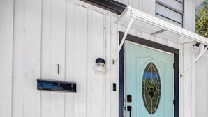 A house with a light blue door, a mailbox, and a welcome mat. - Charming 3BR retreat w/ Private yard- 15 min to Gulf Beaches & 6 min to DTSP (St. Petersburg)