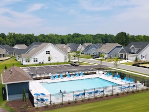 Zona residencial amb piscina envoltada de gandules i una tanca.