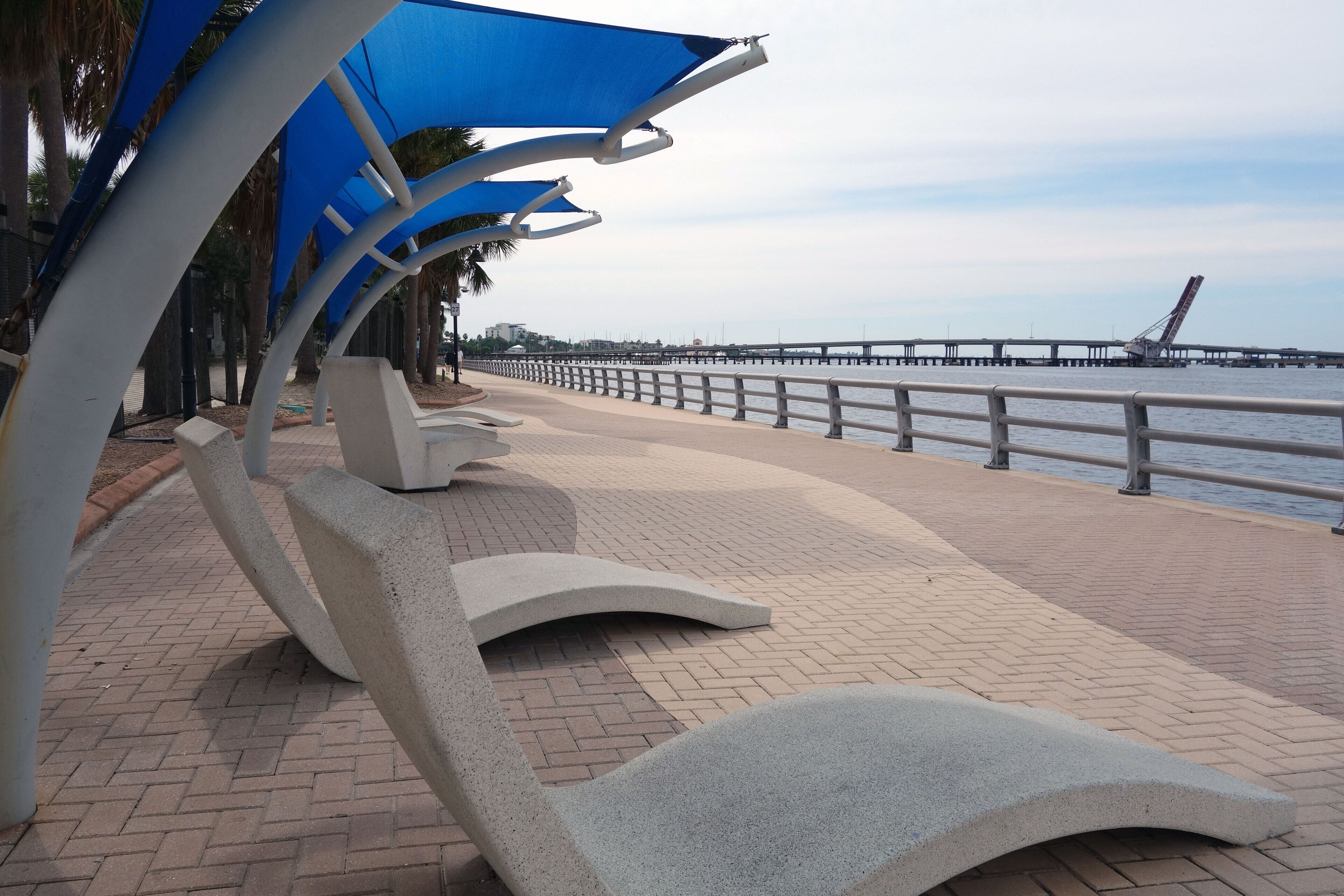 A waterfront promenade with modern seating and a view of the sea.