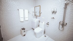 A modern bathroom with a white tiled wall, a toilet, a sink, a shower, and a mirror. - Velana Vibes – Your Tranquil Getaway in the Heart of Mathiveri, Maldives (Mathiveri)