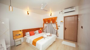 A hotel room with a bed, bedside tables, a ceiling fan, an air conditioning unit, and a door. - Velana Vibes – Your Tranquil Getaway in the Heart of Mathiveri, Maldives (Mathiveri)