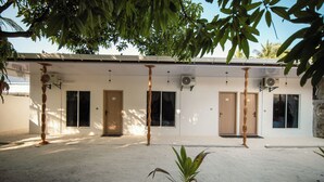 A building with a covered outdoor area, multiple doors, and air conditioning units. - Velana Vibes – Your Tranquil Getaway in the Heart of Mathiveri, Maldives (Mathiveri)