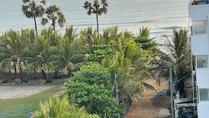 Un camino que lleva a una playa con palmeras y un edificio con la leyenda 'Seaside Resort'.