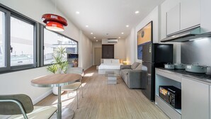 Une cuisine moderne avec un coin repas, un canapé et une petite table.