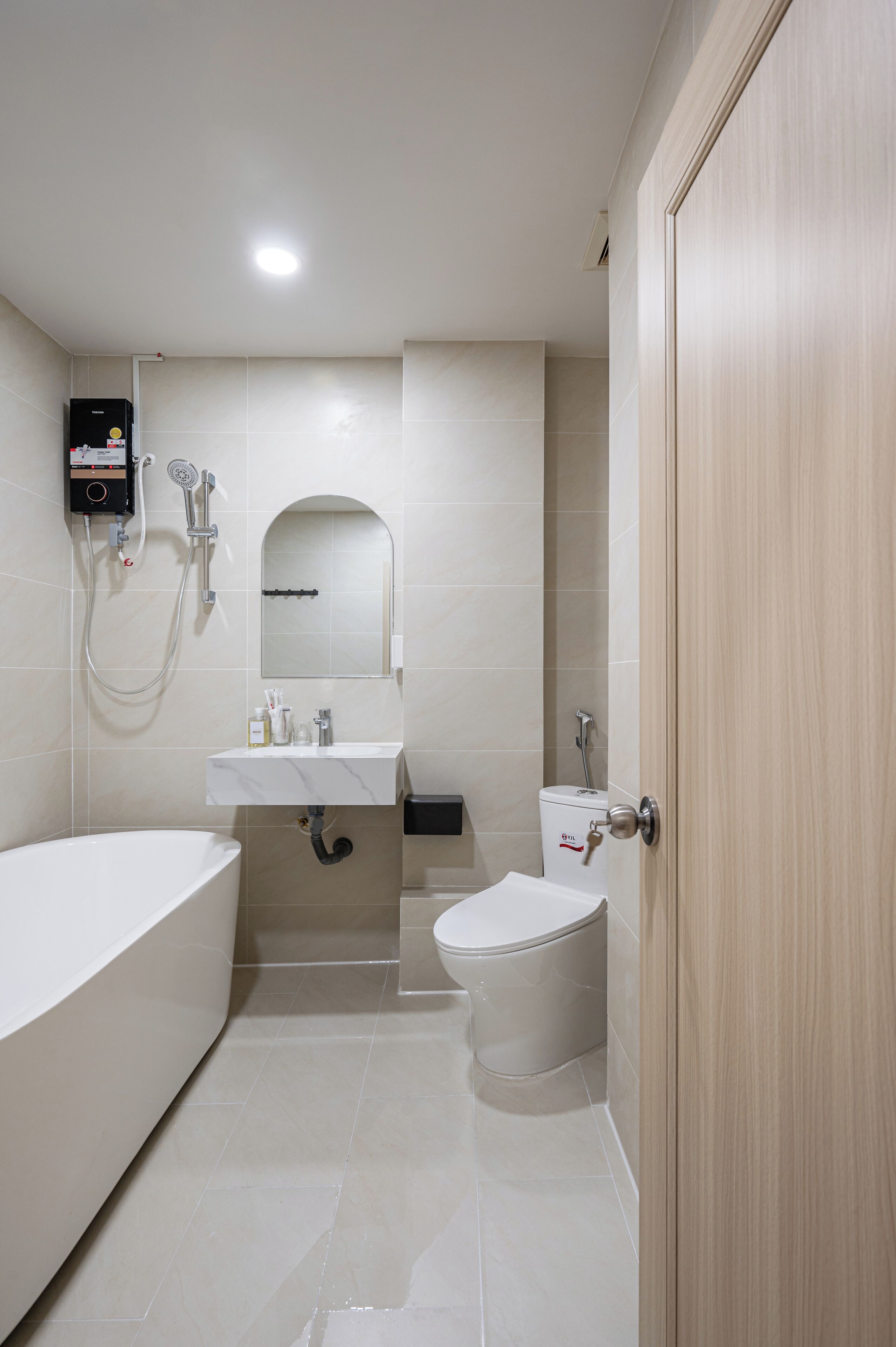 A modern bathroom with a bathtub, toilet, and sink.