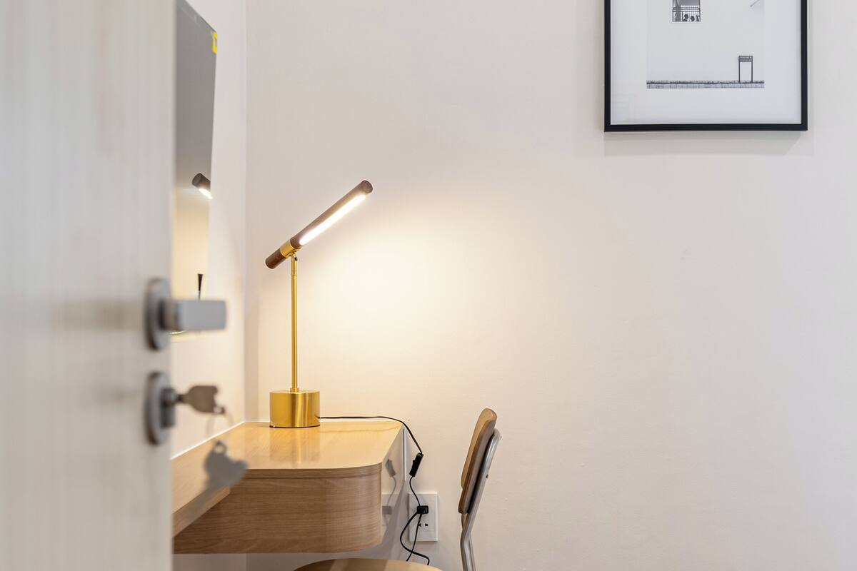 A study area with a desk, chair, and desk lamp.