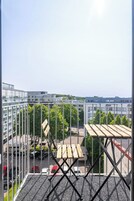 A balcony with a view of a parking lot and buildings.