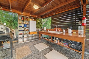 A rustic kitchen with a wooden countertop, a sink, and a fire extinguisher. - Pitahaya Retreat: Cozy Glamping Escape (Cabo Rojo)