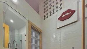 Une salle de bain équipée de toilettes, d’un lavabo et d’une douche.